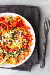 Asian coleslaw salad with white cabbage, carrot, pepper, sesame and cashew nuts. Healthy food concept. Light concrete background. Copy space.