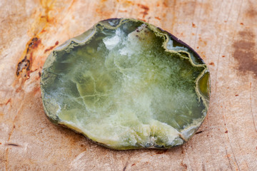 Semi-translucent partially polished Prehnite nodule from the Northern Territory, Australia, on Natural Polished Petrified wood slab from Madagascar.