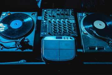 dj mixer with equalizer and vinyl records in nightclub