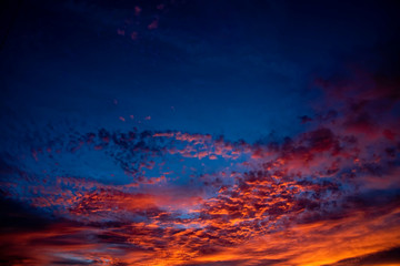 A majestic and awe-inspiration combination of deep blue sky and fiery orange and yellow clouds at sunset.