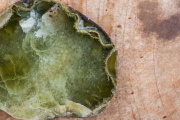 Semi-translucent partially polished Prehnite nodule from the Northern Territory, Australia, on Natural Polished Petrified wood slab from Madagascar.