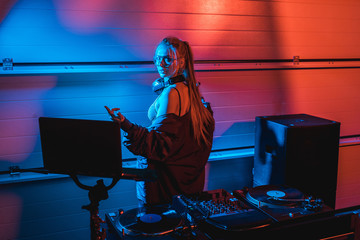  beautiful blonde dj woman gesturing while standing in nightclub