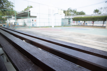 Fototapeta premium empty old wooden bleachers with blurred basketball court background.