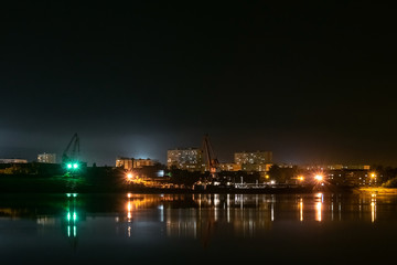 Fototapeta na wymiar River port in the industrial area of the city at night. Urban landscape.