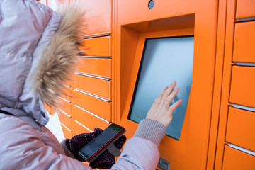 girl enter pin code in street orange ATM