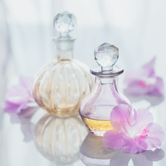 Spa still life with perfume and aromatic oils bottles surrounded by flowers