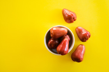 Syzygium Aqueum , Bell fruit or Jambu Air in local Malay language, is a fruit that has a shape like a bell; shot on isolated yellow background.