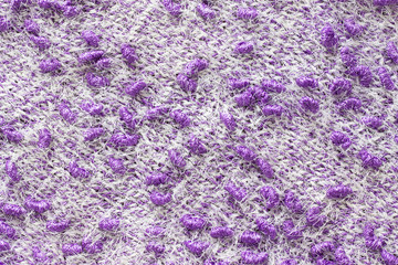 Texture of the knitted fabric. Knitting from yarn, handmade. A pattern of color white and purple yarn, background
