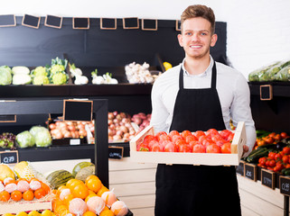 Man seller moving box of persimmons