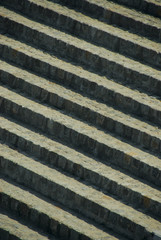Rounded circular Luxury Stone garden steps. On angle, viewed from the left. Crushed red shale and greenery to the right.