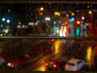 Night lights urban scene. When rainy weather from behind the window