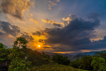 Colorful sunset with cloudy dusk sky in mountains. Green valley hills landscape. Beautiful nature concept. View point. 