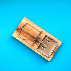 Single wooden mousetrap isolated on blue