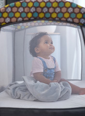 Cute mixed race baby in bed cot