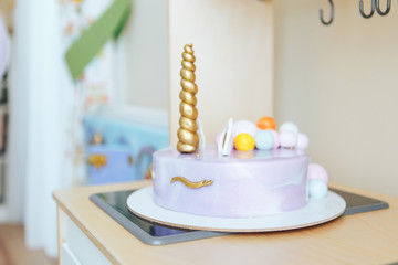 Beautiful homemade cake in the form of a unicorn on a wooden table