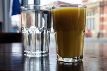 Larges glasses of Orange Juice Friut and Clear Lemonade cold drinks on a dark wooden table.  Close up