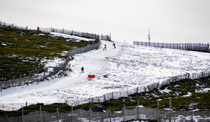 Unrecognizable people practicing skiing in the snow on a ski slope on the mountain on La Covatilla, Bejar (Salamanca)