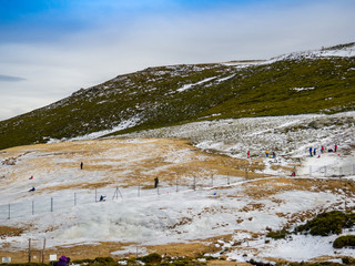 Unrecognizable people gliding on the ice in a slope on the mountain on La Covatilla, Bejar (Salamanca)