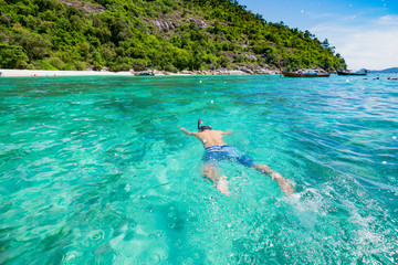 A man was snorkelling  into the Andaman ocean with the crystal clear water