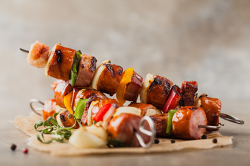 Grilled skewers with sausage, bacon and vegetables.