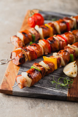 Grilled skewers with sausage, bacon and vegetables.