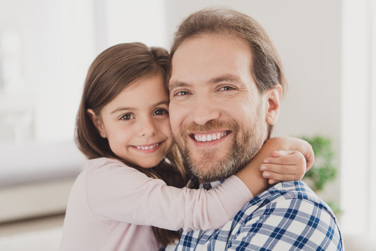 Close up photo two little she her lady girl handsome beard bristle he him his father guy hold hands homey indoors glad togetherness lovely look on camera great morning sunday light flat house