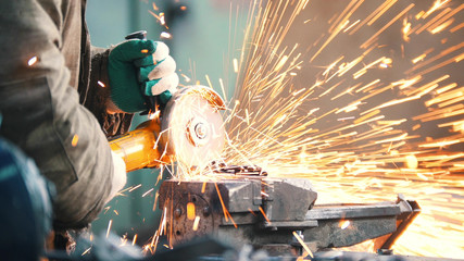 Industrial. Construction site. The man worker grinding. Fire sparkles