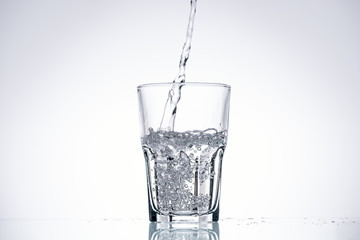 background of water pouring in glass on white with backlit