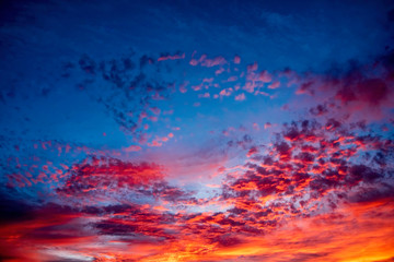 Fototapeta na wymiar A majestic and awe-inspiration combination of deep blue sky and fiery orange and yellow clouds at sunset.