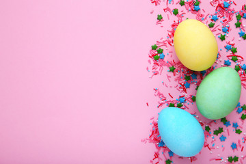 Fototapeta na wymiar Colorful easter eggs with sprinkles on a pink background