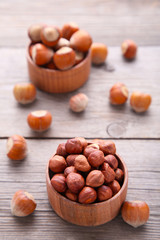 Delicious hazelnut in the wooden bowl on white background