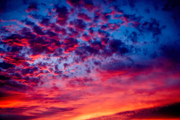 Fototapeta na wymiar A majestic and awe-inspiration combination of deep blue sky and fiery orange and yellow clouds at sunset.