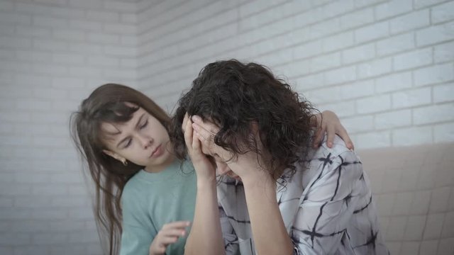 Family problems. The daughter takes pity on the crying mother.