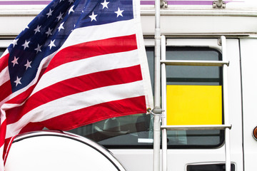 South Shields / Great Britain - May 29, 2016: American flag and blank yellow sign on the back of an imported motorhome.