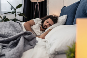 Nice bearded man sleeping in his bed