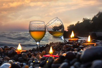 Romantic dinner with candles at sunset.