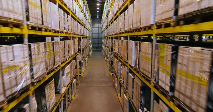 Span drone between the rows in the warehouse with boxes, a large warehouse with boxes, a modern warehouse