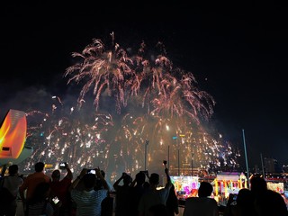 The crowd celebrates the Chinese New Year in Singapore. Silhouettes of people watching a fireworks display. Stock photo.