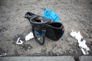 Unwanted handbag discarded on the street left as waste or rubbish
