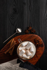 coffee with milk and marshmallow with cinnamon and anise on wooden background top view