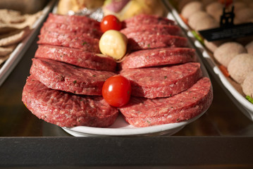 Raw hamburgers on a layer