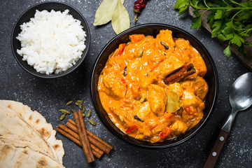 Chicken tikka masala with rice on black top view.