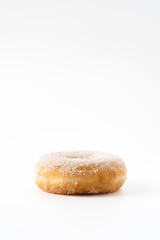 donut mit kristallzucker liegend auf weißem hintergrund freigestellt mit viel freiraum für text
