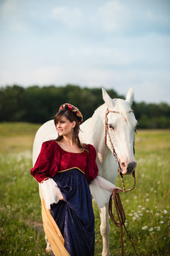 Medieval Princess with a White Horse in a Meadow