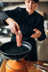 Overhead shot of chef preparing ribeye in a kitchen