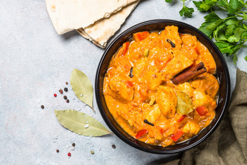 Chicken tikka masala with rice on black top view.