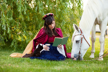 Medieval Princess Reading a Book in the Grass by a Horse