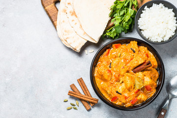 Chicken tikka masala with rice on black top view.