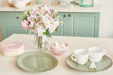 Fototapeta premium bright kitchen in the style of Provence, on the table dishes and a bouquet of flowers in a vase