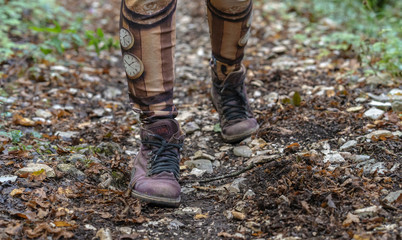 Close-up of the boots of a person walking on the forest path